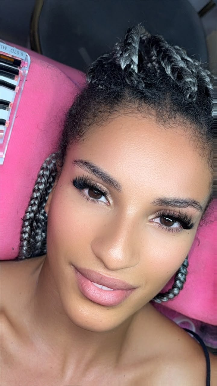 Extensions de cils sur une cliente coiffée de tresses