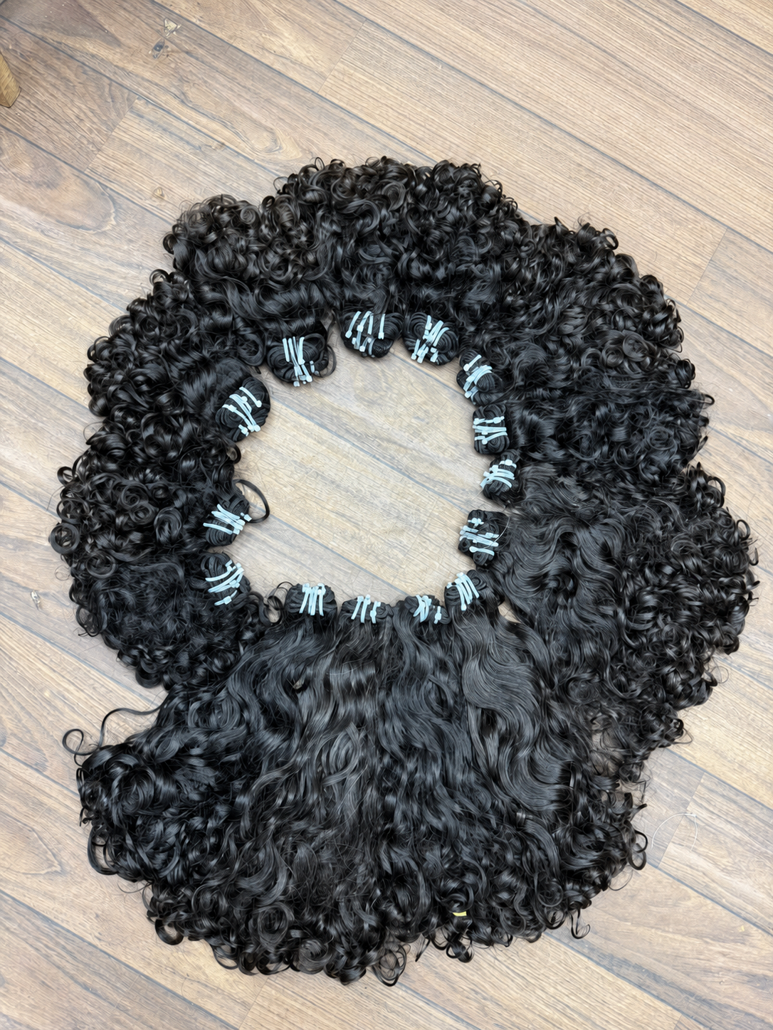 Mèches bouclées pour baby hair sur fond bois épuré